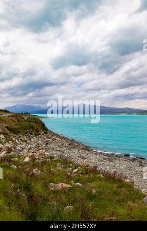 Berge über türkisfarbenem Wasser. Die bergigen Ufer des Lake Pukaki. Neuseeland Stockfoto