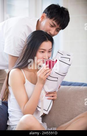 Junger Mann, der seiner Frau Blumen schenkt Stockfoto