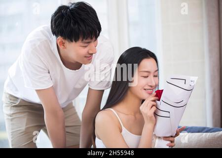 Junger Mann, der seiner Frau Blumen schenkt Stockfoto