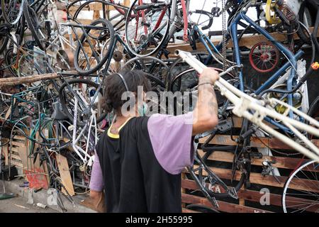 Los Angeles, CA USA - September 28 2021: Obdachloser, der in einem Obdachlosenlager einen riesigen Haufen Fahrräder baute Stockfoto
