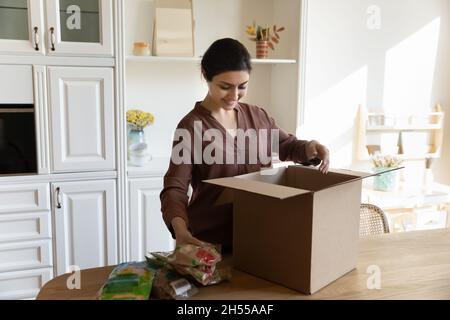 Frau nimmt aus dem Karton bestellte Lebensmittel Stockfoto