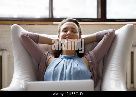 Lächelnd sorglos junge schöne Frau im Sessel entspannen. Stockfoto