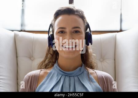 Glückliche junge Frau mit Kopfhörern, die Videokonferenz hält. Stockfoto