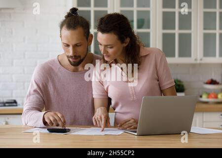 Fokussiertes, besorgtes Familienpaar, das das Budget verwaltet. Stockfoto