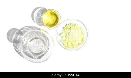 Kosmetische Chemikalien Inhaltsstoff auf weißem Labortisch. Schwefelpulver im chemischen Uhrenglas und Polyaluminiumchlorid-Flüssigkeit im Becher als nächstes platzieren Stockfoto