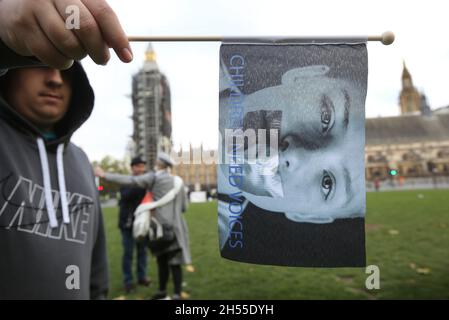 London, Großbritannien. November 2021. Ein Protestler hält eine Flagge hoch, während sich Demonstranten versammeln und gegen die erzwungene Adoption auf dem Parliament Square protestieren.die Demonstranten fordern eine Reform der Familiengerichte. Diese Praxis tritt auf, wenn Kinder nach einer Intervention der Kinderdienste dauerhaft von ihren Eltern entfernt und anschließend zur Adoption bereit gestellt werden. Kredit: SOPA Images Limited/Alamy Live Nachrichten Stockfoto