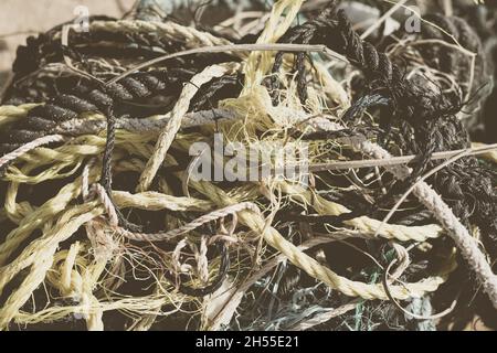 E Schließen mehrfarbig schwarz weiß gelb alte Fischerei verdrehte Baumwollseile Haufen Haufen Durcheinander Detail. Konzept Tangle Mess Mix Mischmasch Labyrinth Stockfoto