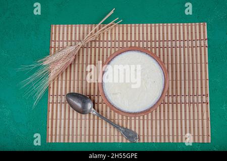 Natürlich, Joghurt in Auflaufschüssel auf Holztisch mit Löffel.Close Up taken.Turkish und Greek traditionelle Milchprodukte Joghurt oder angespannter Joghurt in Fass Stockfoto