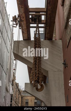 Kettenzug zum Heben von Gewichten in einer alten Fabrik Stockfoto