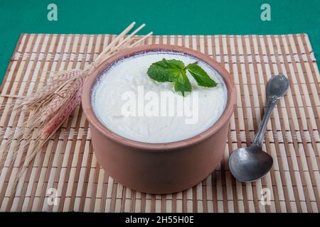 Natürlich, Joghurt in Auflaufschüssel auf Holztisch mit Löffel.Close Up taken.Turkish und Greek traditionelle Milchprodukte Joghurt oder angespannter Joghurt in Fass Stockfoto