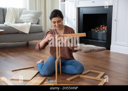 Indische Frau sammelt neuen Stuhl mit Holzbrettern Stuhl Details Stockfoto