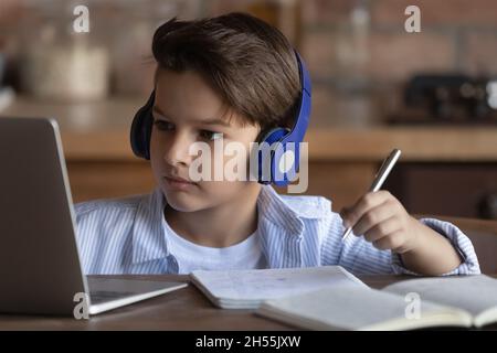 Jugendlicher, der von zu Hause aus mit einem Laptop an einem Headset studiert Stockfoto