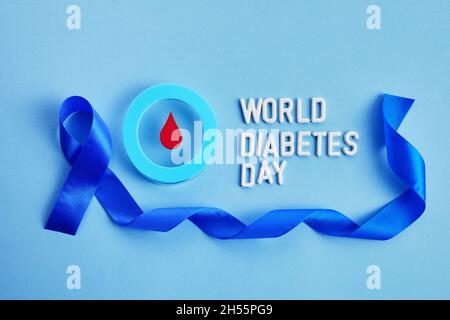 Bewusstsein für den Weltdiabetestag. Blaues Band und Kreis mit Blutstropfen. Stockfoto