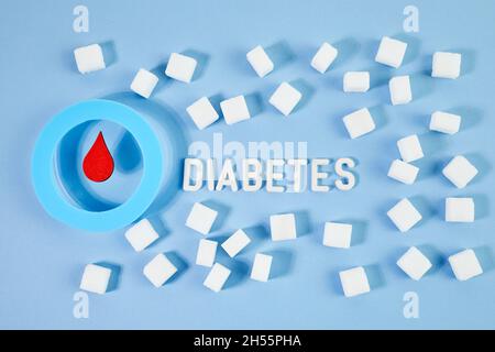 Bewusstsein für den Weltdiabetestag. Blauer Kreis mit Bluttropfen und Zuckerwürfeln. Stockfoto