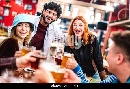 Fröhliche Menschen trinken Bier mit gemischtem Essen in der Halle - Getränke Life Style Konzept für junge Freunde genießen Abhängen Zeit zusammen essen Stockfoto