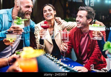 Hipster-Freunde toasten bunte, ausgefallene Drinks an der Modebar - trendige Leute, die Spaß miteinander haben, Cocktails zur Happy Hour zu trinken Stockfoto