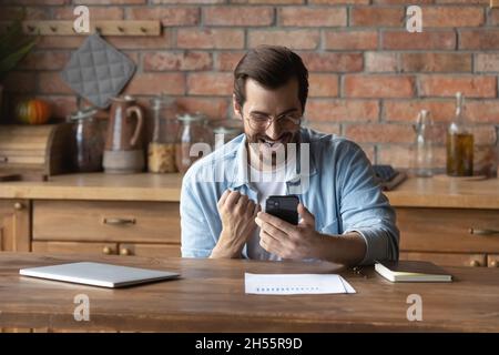 Aufgeregt Mann Check E-Mail auf dem Smartphone erhalten attraktive Stellenangebot Stockfoto