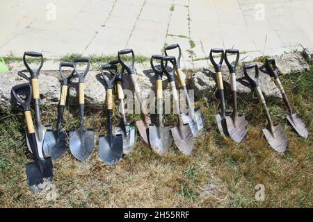 Schaufel zum Pflanzen, saisonale Arbeiten im Garten . Schaufeln zum Graben des Bodens auf einem Erdhaufen . Viele Schaufeln schaufeln . Stockfoto