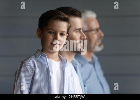 Drei verschiedene Männer Großvater Vater kleiner Junge stehen in Reihe Stockfoto