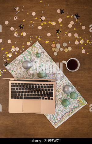Weihnachtsreise mit Laptop und Karte, Draufsicht. Stockfoto