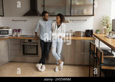 Junges afroamerikanisches Paar, das in einer modernen Küche kommuniziert. Stockfoto