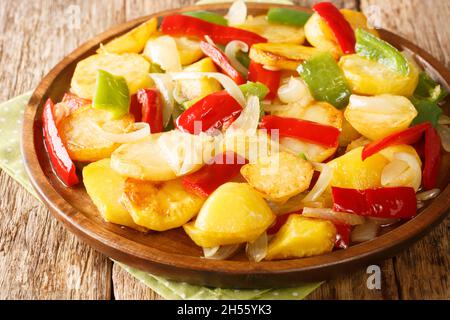 Patatas a lo pobre ist ein einfaches Kartoffelgericht aus der andalusischen Küche, das aus geschnittenen Kartoffeln besteht und in Olivenöl mit Zwiebeln und Paprika in der Nähe in t gebraten wird Stockfoto