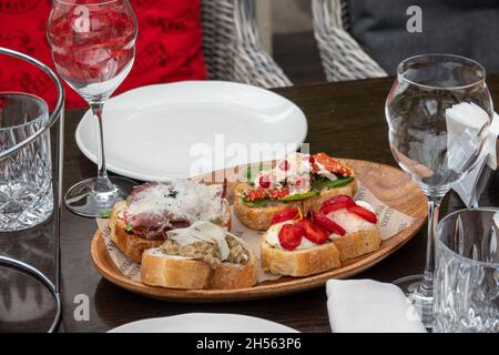 Gemischte Bruschetta mit verschiedenen Belägen. Appetitliche Bruschetta oder Crudo Crostini. Verschiedene kleine Sandwiches. Stockfoto