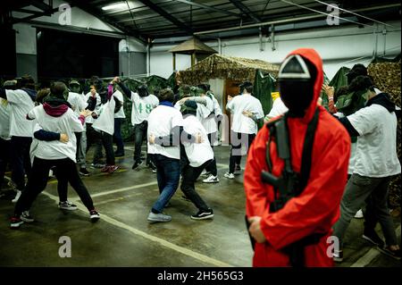 Mailand, Italien. November 2021. Menschen in Kostümen der Fernsehserie „Squid Game“ tanzen während einer Veranstaltung, die von Enigma Room in Settimo Milanese organisiert wird. Quelle: Piero Cruciatti/Alamy Live News Stockfoto