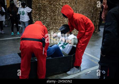 Mailand, Italien. November 2021. Menschen in Kostümen der Fernsehserie „Squid Game“ während einer Veranstaltung, die von Enigma Room in Settimo Milanese organisiert wurde. Quelle: Piero Cruciatti/Alamy Live News Stockfoto