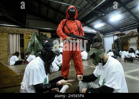 Mailand, Italien. November 2021. Menschen in Kostümen der Fernsehserie „Squid Game“ während einer Veranstaltung, die von Enigma Room in Settimo Milanese organisiert wurde. Quelle: Piero Cruciatti/Alamy Live News Stockfoto