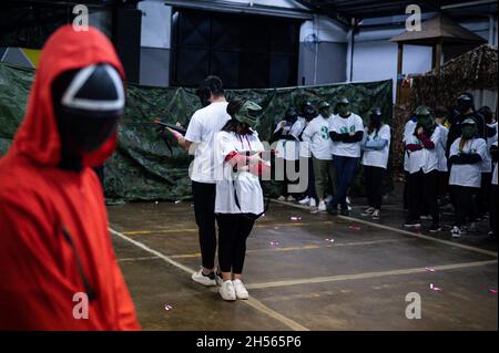 Mailand, Italien. November 2021. Menschen in Kostümen der Fernsehserie „Squid Game“ während einer Veranstaltung, die von Enigma Room in Settimo Milanese organisiert wurde. Quelle: Piero Cruciatti/Alamy Live News Stockfoto