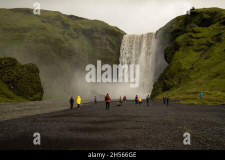 Touristen bewundern den majestätischen Wasserfall im Süden Islands Stockfoto