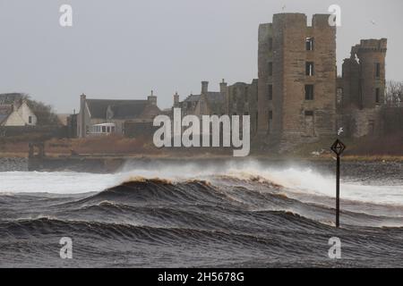 Thurso, Schottland. Nov. 7 2021. An der Mündung des Flusses Thurso brechen orkanartige Wellen mit Schloss Thurso im Hintergrund. Stockfoto