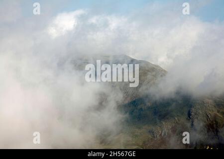 Nebel wirbelt um den Gipfel von Wetherlam vom Gipfel des alten Mannes von Coniston in der Nähe von Coniston, dem Lake District Cumbria England aus gesehen Stockfoto