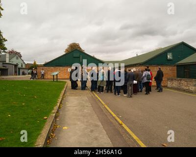 Besucher hören einem Fremdenführer im Bletchley Park mit einigen Codebreaker-Hütten hinter Bletchley Buckinghamshire England Stockfoto