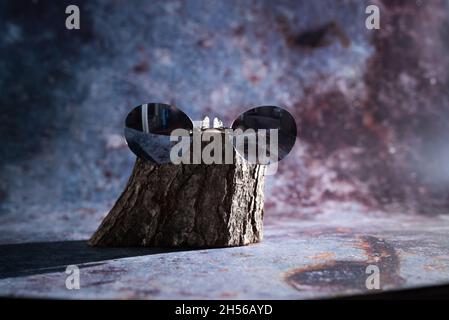 Sonnenbrille auf einem Holzsockel auf blauem Hintergrund Stockfoto
