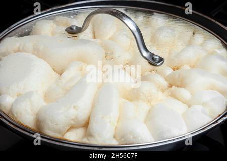 Roher kaiserschmarrn-Teig beim Kochen in einer Metallpfanne auf dem Ofen Stockfoto