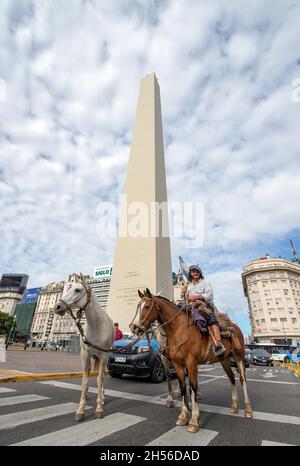 Buenos Aires, Argentinien. November 2021. Marcos Villamil reitet mit seinen drei Pferden Torto, Wayra und Mora am Obelisk vorbei. Rund 8,600 Kilometer hat der 29-Jährige mit seinen drei Pferden auf seiner Reise durch Argentinien zurückgelegt. Nach 14 Monaten im Sattel kehrt er nun nach Buenos Aires zurück. Quelle: Florencia Martin/dpa/Alamy Live News Stockfoto