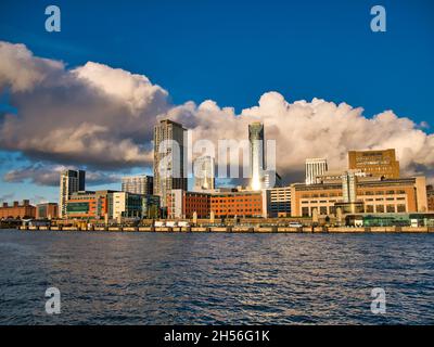 Moderne Bürogebäude und Apartments am Wasser in Liverpool am Fluss Mersey. Aufgenommen an einem sonnigen Tag mit blauem Himmel und weißen Wolken. Stockfoto