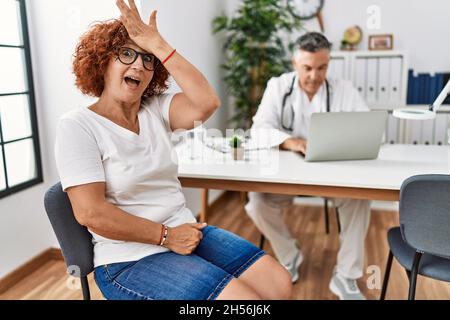 Ältere Frau sitzt bei Arzttermin überrascht mit Hand auf Kopf für Fehler, erinnern Sie sich Fehler. vergessen, schlechtes Gedächtnis-Konzept. Stockfoto