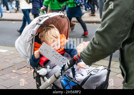 Amsterdam, Niederlande, 06. November 2021. Kleiner Junge im Kinderwagen, von seinem Vater geschoben, mit Schild, das lautet: Keine 5 m Wasser!Quelle: Steppeland/Alamy Live News Stockfoto