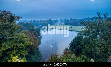 Avington, Großbritannien - 10. Oktober 2021: Avington House und See bei einem Herbstaufgang, South Downs National Park, Hampshire, Großbritannien Stockfoto
