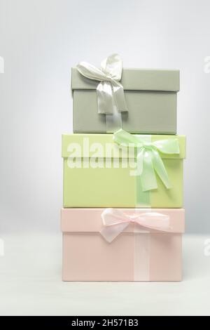 Pastellgrün und graue Geschenkschachteln stehen übereinander mit weißem Hintergrund Stockfoto