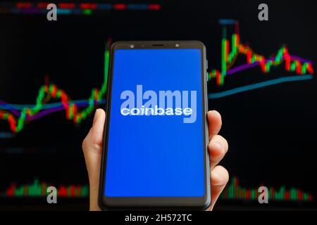Ukraine, Odessa - Oktober, 9 2021: Coinbase mobile App läuft auf dem Smartphone-Bildschirm mit Trading Candlestick Chart im Hintergrund. Coinbase ist Amerikaner Stockfoto