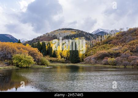 Früher Schnee auf den Gipfeln der La Sal Mountains mit den Espenbäumen in brillanter Herbstfarbe in der Nähe von Moab, Utah. Stockfoto