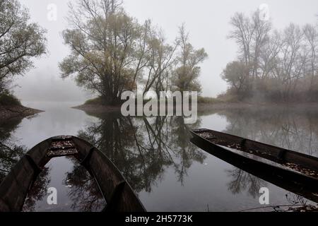 Zwei Holzboote am Ufer an einem nebligen Morgen in Plittersdorf, Deutschland Stockfoto