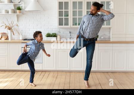 Hübscher afroamerikanischer Vater, der dem kleinen Sohn das Tanzen beibringt Stockfoto