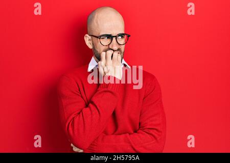 Junge Glatze Mann trägt Freizeitkleidung und Brille gestresst und nervös mit den Händen auf den Mund beißende Nägel. Angstproblem. Stockfoto