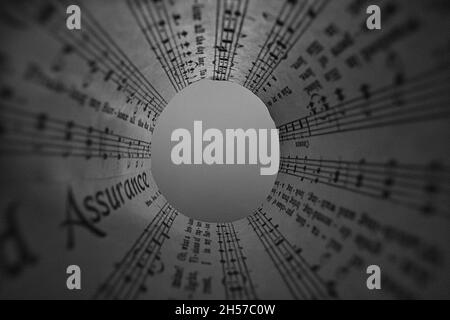 Fotoidee mit Notenblättern gerollt und transparent. Abstrakt und künstlerisch dargestellt Stockfoto