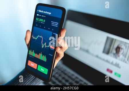 Trader streamen Online-Finanzbildungsklasse mit Senior Coach mit Mobiltelefon - Forex Trading-Konzept Stockfoto